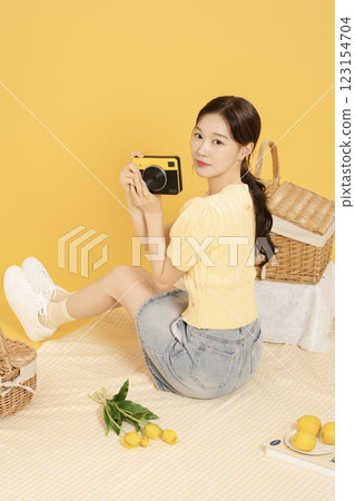 A woman in her 20s spreading out a mat and enjoying a picnic 123154704
