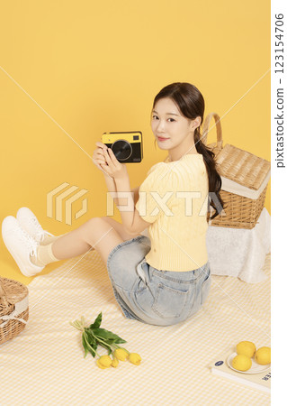 A woman in her 20s spreading out a mat and enjoying a picnic 123154706