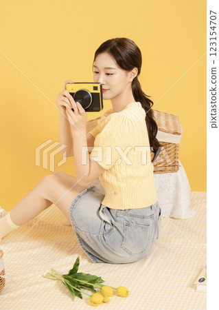 A woman in her 20s spreading out a mat and enjoying a picnic 123154707