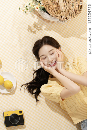 A woman in her 20s spreading out a mat and enjoying a picnic A woman in her 20s spreading out a mat and enjoying a picnic 123154726