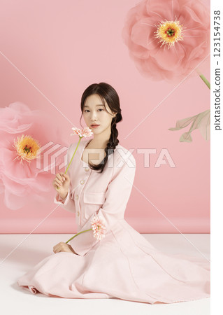 An innocent woman in her 20s wearing a pink two-piece with a large flower in the background. An innocent woman in her 20s wearing a pink two-piece with a large flower in the background. 123154738