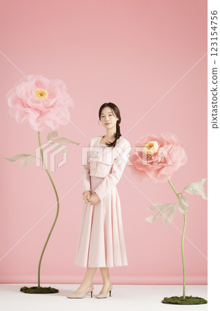 An innocent woman in her 20s wearing a pink two-piece with a large flower in the background. An innocent woman in her 20s wearing a pink two-piece with a large flower in the background. 123154756
