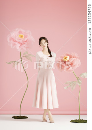 An innocent woman in her 20s wearing a pink two-piece with a large flower in the background. An innocent woman in her 20s wearing a pink two-piece with a large flower in the background. 123154766