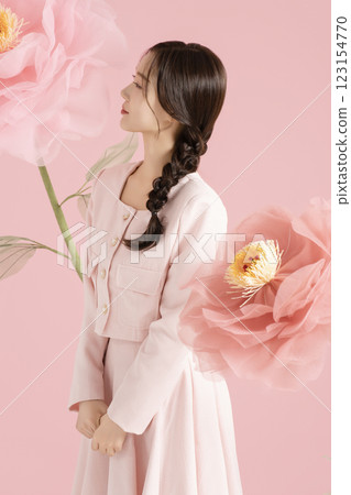 An innocent woman in her 20s wearing a pink two-piece with a large flower in the background. An innocent woman in her 20s wearing a pink two-piece with a large flower in the background. 123154770