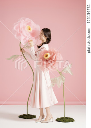 An innocent woman in her 20s wearing a pink two-piece with a large flower in the background. An innocent woman in her 20s wearing a pink two-piece with a large flower in the background. 123154781