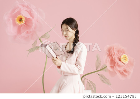 An innocent woman in her 20s wearing a pink two-piece with a large flower in the background. An innocent woman in her 20s wearing a pink two-piece with a large flower in the background. 123154785