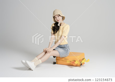 A woman in her 20s traveling with a suitcase A woman in her 20s traveling with a suitcase 123154873