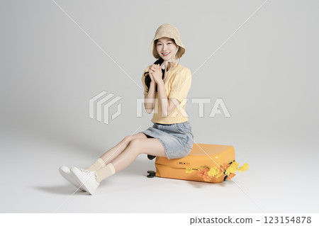 A woman in her 20s traveling with a suitcase A woman in her 20s traveling with a suitcase 123154878