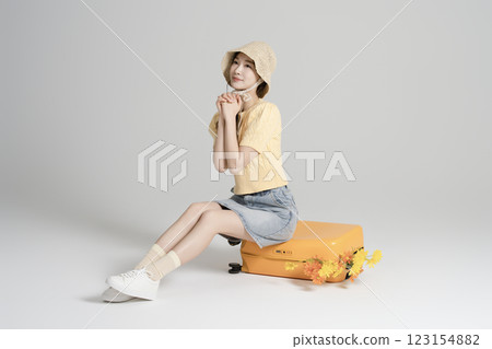 A woman in her 20s traveling with a suitcase A woman in her 20s traveling with a suitcase 123154882