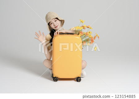 A woman in her 20s traveling with a suitcase A woman in her 20s traveling with a suitcase 123154885