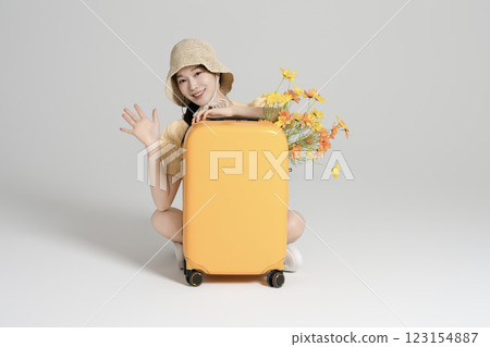 A woman in her 20s traveling with a suitcase 123154887