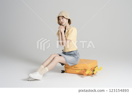A woman in her 20s traveling with a suitcase 123154893