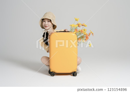 A woman in her 20s traveling with a suitcase A woman in her 20s traveling with a suitcase 123154896