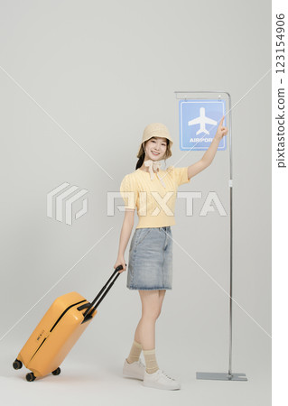 A woman in her 20s waiting for the airport bus with a suitcase 123154906