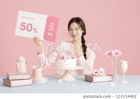 A woman in her 20s sitting in front of a cake and holding a coupon 123154962