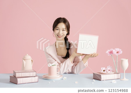 A woman in her 20s sitting in front of a table set with a bright spring concept and holding a box. A woman in her 20s sitting in front of a table set with a bright spring concept and holding a box. 123154988