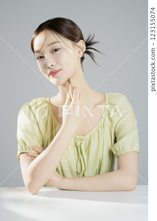 A pretty woman in her 20s wearing bright clothes, sitting and posing with cosmetics A pretty woman in her 20s wearing bright clothes, sitting and posing with cosmetics 123155074