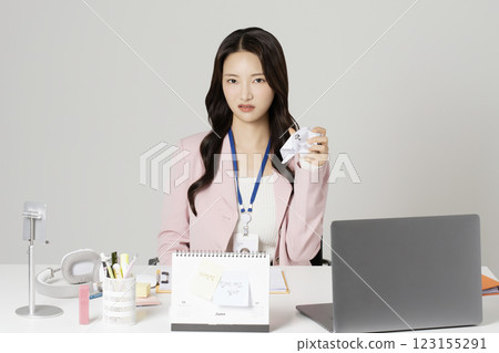 MZ employee sitting in front of desk with crumpled paper 123155291
