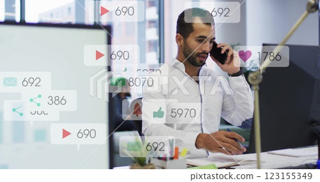 Image of data processing over biracial businessman talking on smartphone in office Image of data processing over biracial businessman talking on smartphone in office 123155349