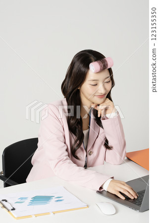 MZ employee using a laptop while wearing a hair roller MZ employee using a laptop while wearing a hair roller 123155350