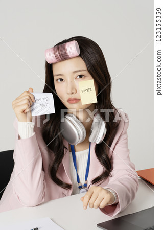 MZ employee wearing a hair roller and sticking a post-it note on his face 123155359