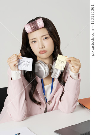 MZ employee holding a hair roll and a post-it note MZ employee holding a hair roll and a post-it note 123155361