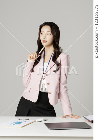 MZ employee in his 20s standing in front of his office desk 123155575