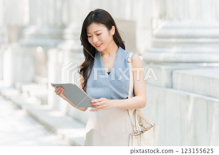 一位女商人在商業區看著平板電腦 123155625