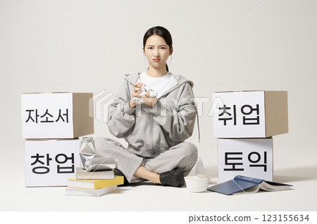 A job seeker in his 20s carrying heavy boxes including personal statements, employment, starting a business, and TOEIC. 123155634