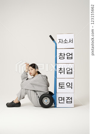 A job seeker in his 20s carrying heavy boxes including personal statements, employment, starting a business, and TOEIC. 123155662