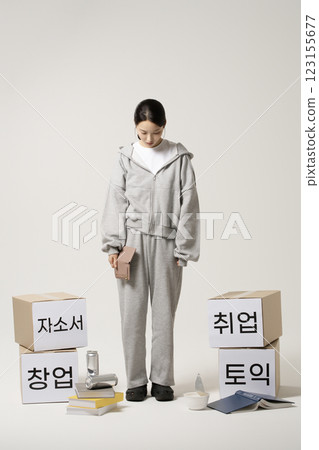 A job seeker in his 20s carrying heavy boxes including personal statements, employment, starting a business, and TOEIC. 123155677