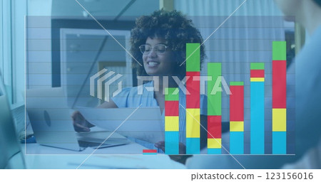 Businesswoman reviewing documents, bar chart image over office background 123156016