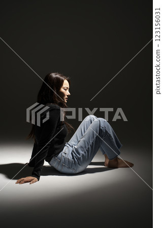 Portrait of a woman sitting in a lighted area Portrait of a woman sitting in a lighted area 123156031