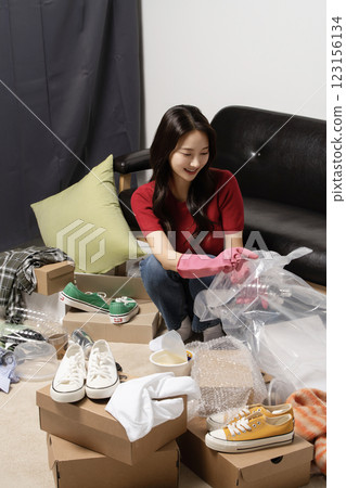 A young man in his 20s cleaning his room wearing rubber gloves 123156134