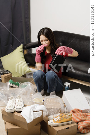 A young man in his 20s cleaning his room wearing rubber gloves 123156143