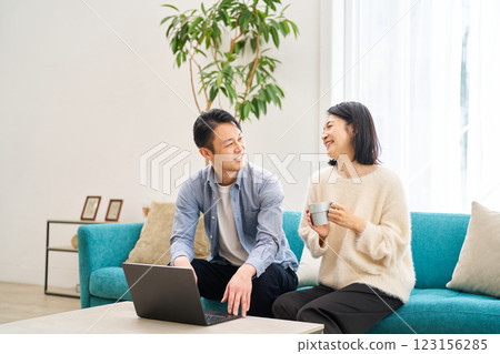 一對夫婦一邊看著電腦顯示器一邊聊天 123156285