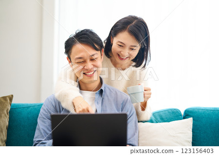 A couple chatting while looking at a computer monitor A couple chatting while looking at a computer monitor 123156403