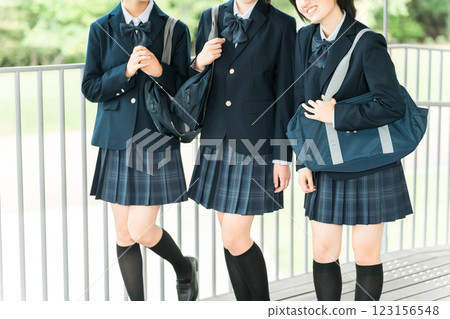 Friendly female students walking through the school building with smiles on their faces (going to school, going home, commuting to school) 123156548