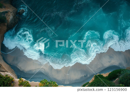 Ocean is calm and the waves are small. The beach is rocky and the water is blue. Aerial view 123156900