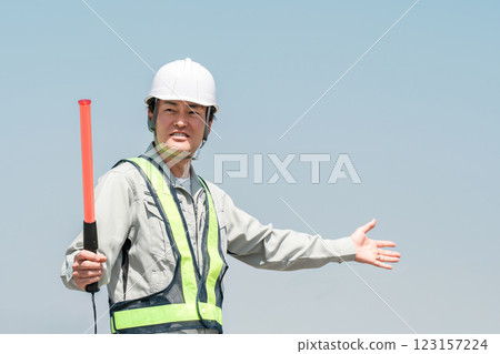 A male security guard/traffic controller directing traffic 123157224