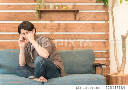 Young Asian man talking on smartphone (crying, sad, breaking up, tears, apologizing, effeminate, depressed) 123158184