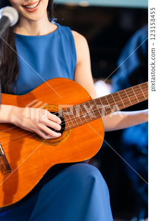 Men and women jamming on stage with guitar and piano, no faces 123158455