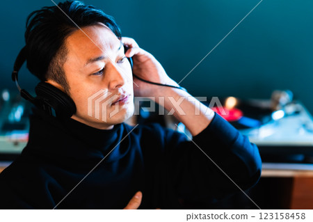 Middle-aged man listening to music through headphones Middle-aged man listening to music through headphones 123158458