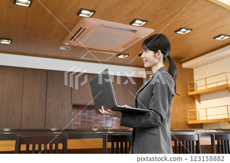 一位穿著西裝的女士在餐廳裡查看電腦 一位穿著西裝的女士在餐廳裡查看電腦 123158882