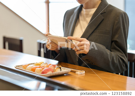 A female customer taking a photo of her food 123158892