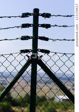 Close-up view of fencing that is made of steel wire. A device that prevents the entry of strangers and animals. 123159417