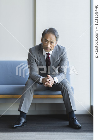 A man in his 60s wearing a suit, looking at the camera, portrait 123159440