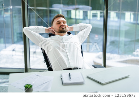 Confident Businessman Relaxing in Modern Office Surrounded by Natural Light 123159672