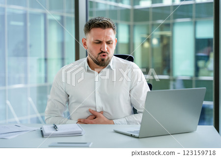 Professional Businessman Experiencing Discomfort While Working on a Laptop 123159718