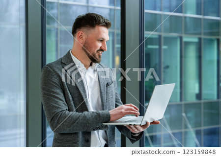 Confident Business Professional Using a Laptop in a Modern Office Setting 123159848